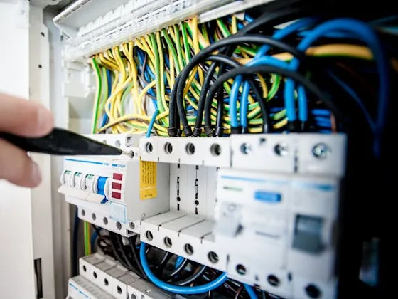 Close-up of a professional electrical panel installation with organized breakers and color-coded wiring