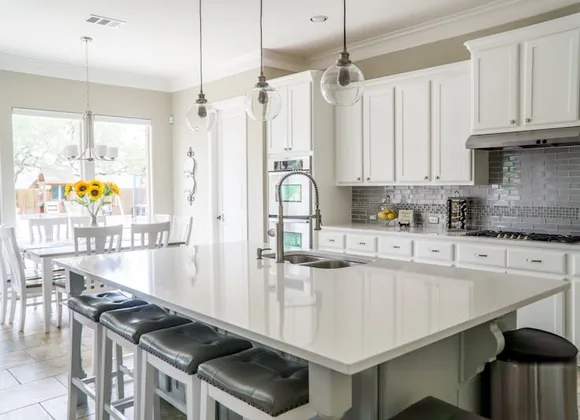 Modern kitchen with professional pendant and recessed lighting installed by a licensed electrician